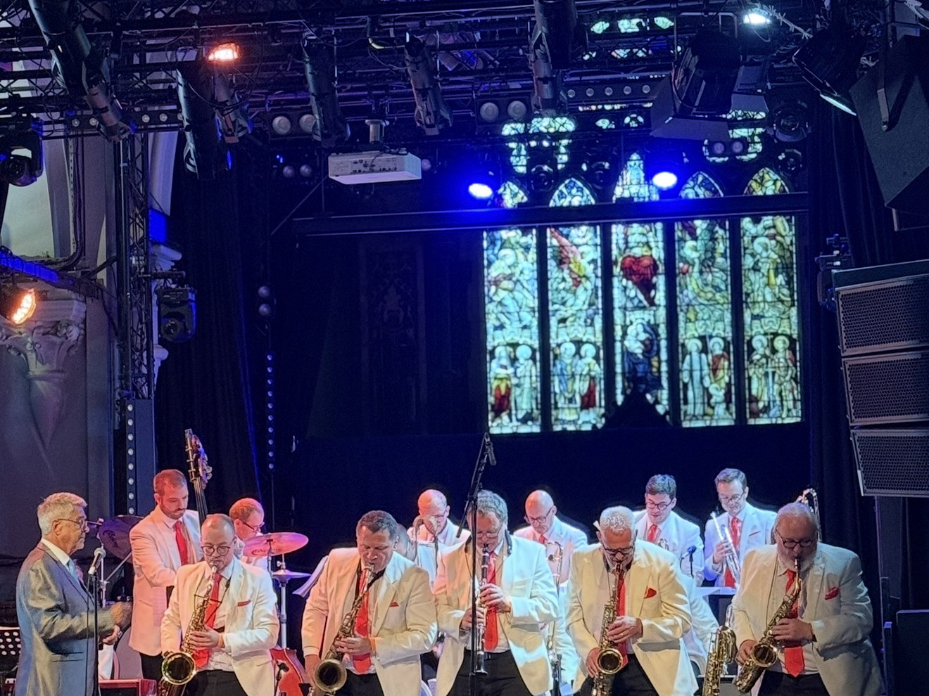 A band performing on stage under coloured lighting